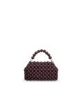 A small structured handbag covered in dark plum purple wood beads, featuring a matching beaded top handle and gold-tone hardware, set against a plain white background.